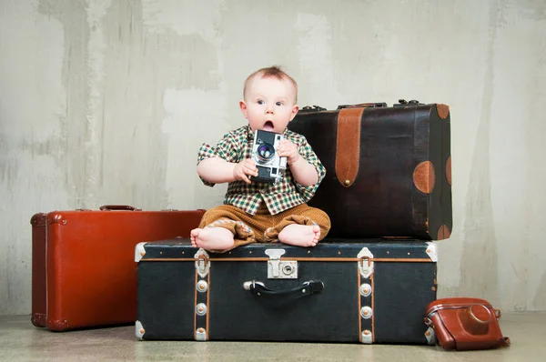 Kind sitzt auf Koffer und Kamera in der Hand — Stockfoto