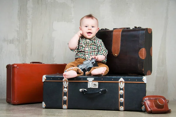 Dziecko siedzi na walizkę i z kamerą w ręku — Zdjęcie stockowe