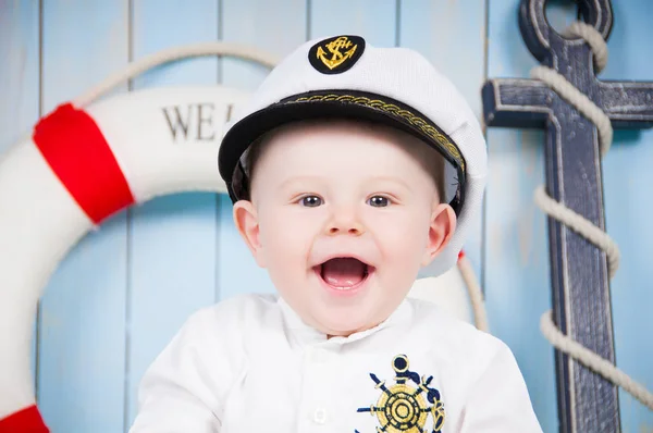 Un piccolo capitano allegro in un interno marittimo — Foto Stock