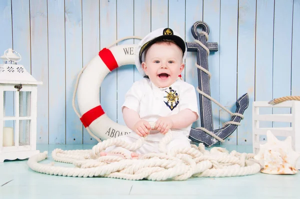 En liten glad pojke kapten i maritima inredningen — Stockfoto