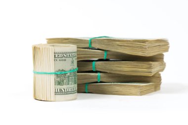 100 dolar faturaları bükülmüş bir demet dolar paketleri üzerinde duruyor.