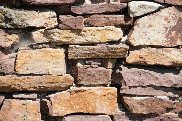 Achtergrond van een muur gemaakt van natuursteen is bruin. — Stockfoto