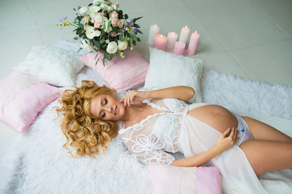 Une fille enceinte aux cheveux roux incroyablement belle avec des fleurs fraîches . — Photo