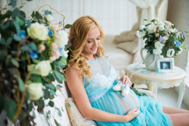 En güzel hamile kız taze çiçekler ile nazik bir iç.