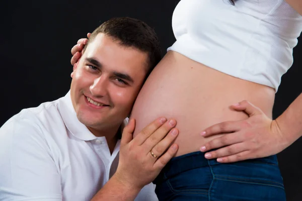 9 meses. Pareja embarazada esperando el nacimiento de un hijo. Fondo negro . —  Fotos de Stock