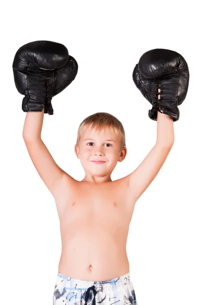 Kleiner süßer Junge mit Boxhandschuhen feiert seinen Sieg auf dem leeren Wandhintergrund — Stockfoto