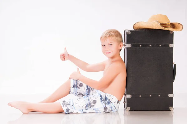 Kleine jongen reiziger in hoed zit op koffer — Stockfoto