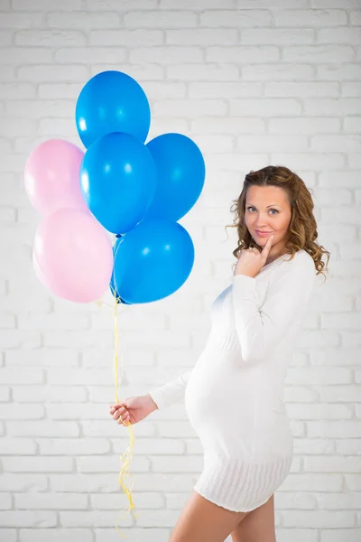 Mulher grávida feliz com balões na mão, rosa e azul . — Fotografia de Stock