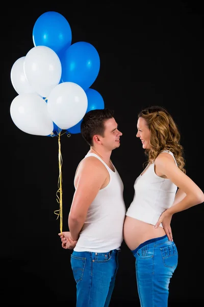 Чоловік дає своїй вагітній дружині повітряні кулі — стокове фото