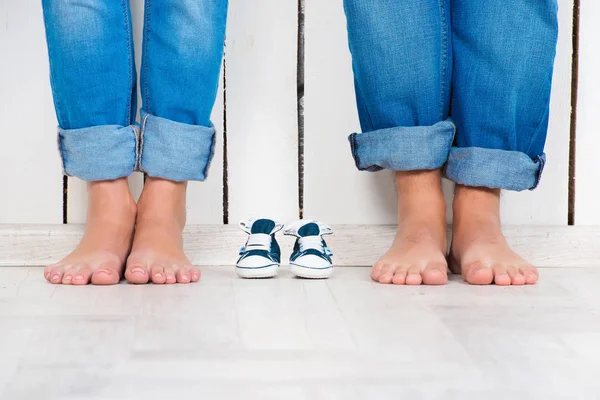 Aspetto un bambino. Donna incinta, gravidanza, maternità. Una famiglia felice. Mamme, papà e babys bootee. Look familiare — Foto Stock