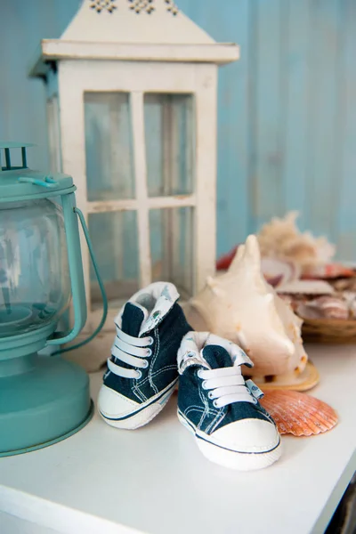 Çocuk kot pantolon spor ayakkabı içinde deniz iç kabukları arka planı. — Stok fotoğraf