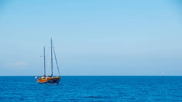 Un barco con las velas en el horizonte del mar . — Foto de Stock