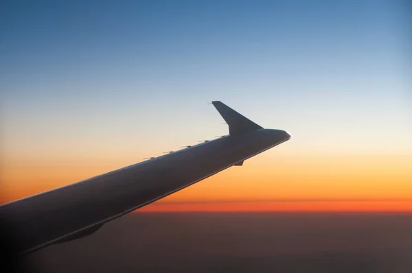 Wing of a Airplane at sunset with clouds — Stock Photo, Image