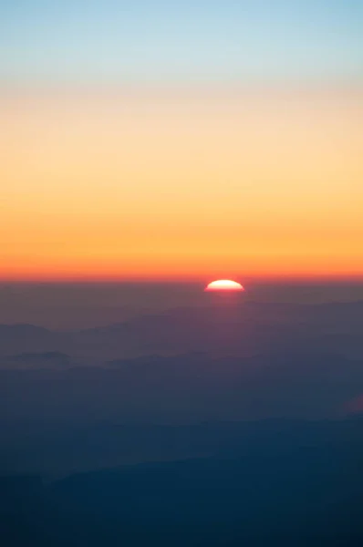 Pôr-do-sol laranja nas montanhas. Vista de uma altura . — Fotografia de Stock