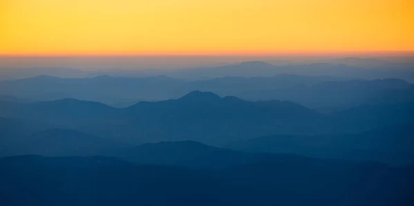 Orange sunset in the mountains. View from a height. — Stock Photo, Image