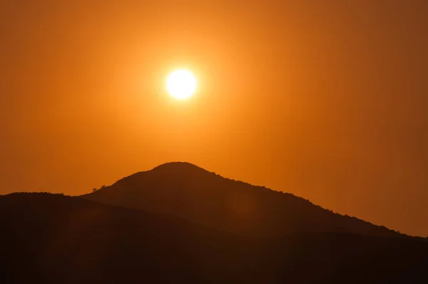 Pôr-do-sol laranja nas montanhas. Vista de uma altura . — Fotografia de Stock