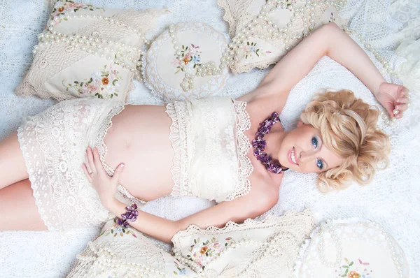 Güzel hamile kadın kanepede yatan lüks saç siyah. Üstten Görünüm. — Stok fotoğraf