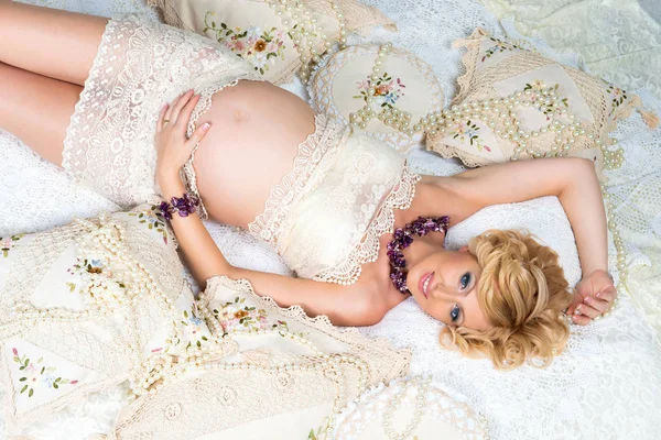 Mulher grávida bonita com cabelo luxuoso preto deitado no sofá. Vista superior . — Fotografia de Stock