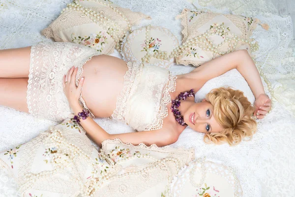 Beautiful pregnant woman with luxurious hair black lying on the couch. Top view. — Stock Photo, Image