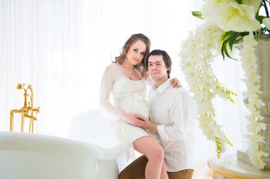 Güzel hamile kadın kocasıyla karnı banyoda sarılma