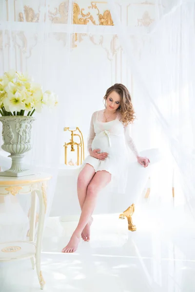 Schöne schwangere Frau in weißer Unterwäsche im Badezimmer — Stockfoto