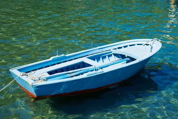 Um velho barco perto de uma ponte de madeira em um belo lago. Barco de pesca no cais . — Fotografia de Stock