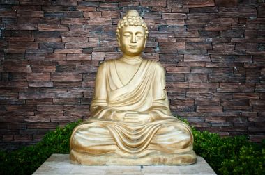 Bir tuğla duvar arka plan altın Buddha statue