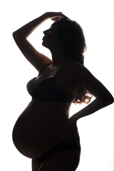 Silhouette di donna incinta su sfondo bianco — Foto Stock