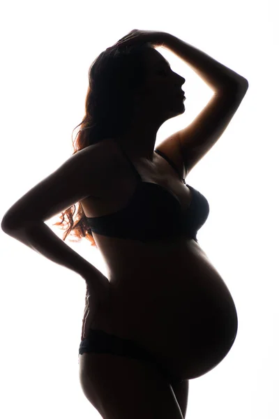 Silhouet van zwangere vrouw op een witte achtergrond — Stockfoto