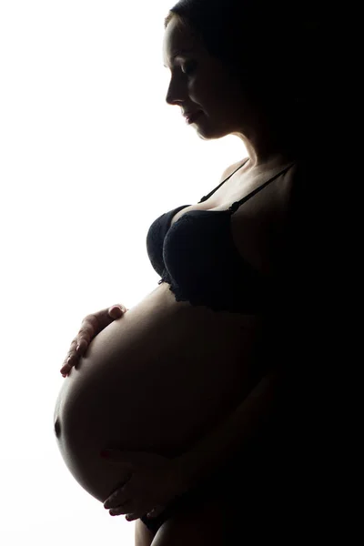 Silhouet van zwangere vrouw op een witte achtergrond — Stockfoto