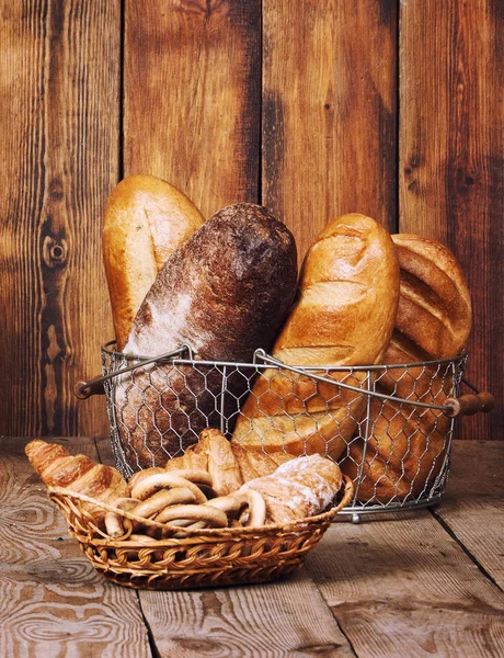 Farklı ekmek sepeti ahşap arka plan üzerinde kulakları ile
