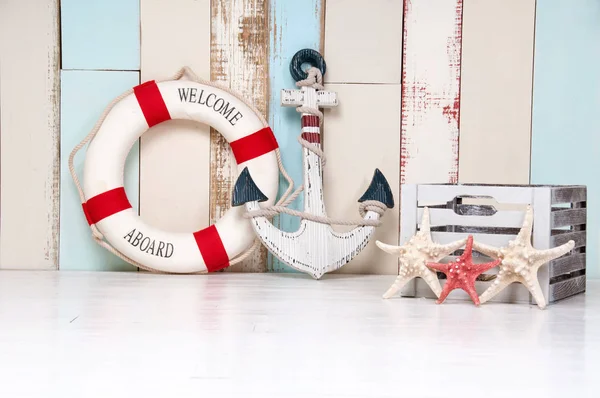 Složení na mořský motiv kotvy a záchranný kruh, mušle a hvězdice na dřevěné pozadí — Stock fotografie