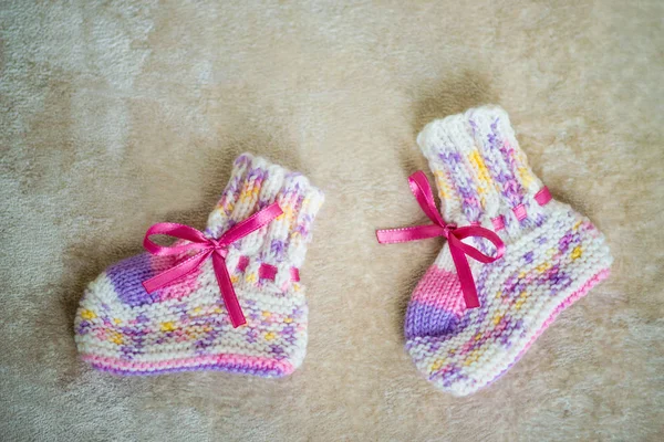 Knitted baby socks on a wooden background. — Stock Photo, Image