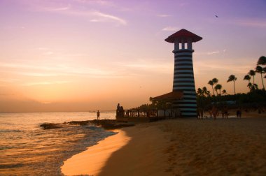 Karayip Denizi'nin kıyısında çizgili kırmızı beyaz feneri. Dominik Cumhuriyeti.