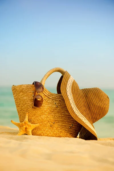 Сумка с шляпой и очками на пляже . — стоковое фото
