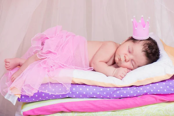 刚出生的婴儿女孩睡在床上的床垫上的皇冠。童话公主和豌豆 — 图库照片