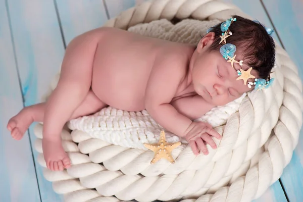 Retrato de perto de uma menina recém-nascida adormecida no arco marítimo de estrelas do mar e pérolas — Fotografia de Stock