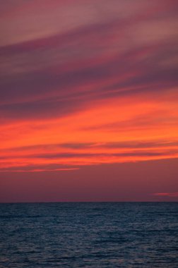 Deniz ufukta turuncu günbatımı manzarası