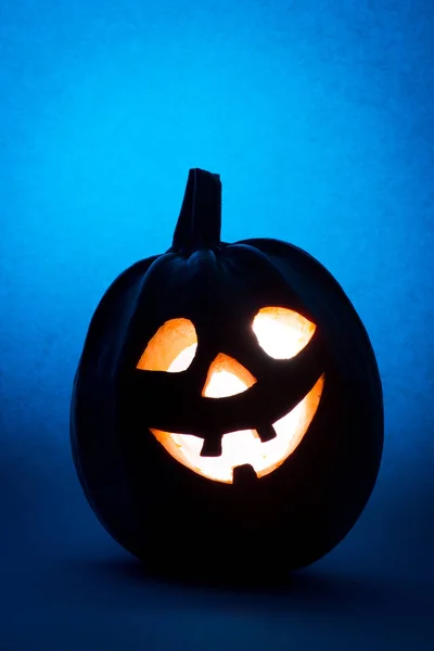 Halloween dýně, silueta legrační obličej na modrém pozadí. — Stock fotografie