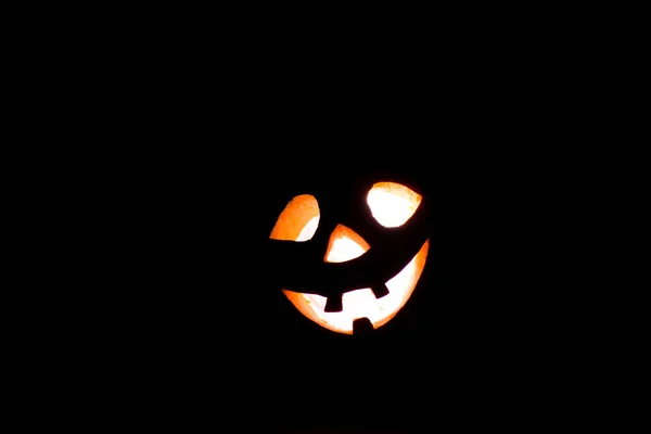 Halloween-Kürbis mit gruseligem Gesicht auf schwarzem Grund — Stockfoto