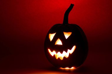 Cadılar Bayramı Balkabağı, kırmızı zemin üzerine komik surat