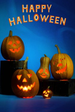 Mutlu Cadılar Bayramı Balkabağı şamdanlı, komik surat yüz mavi bir arka plan üzerinde.