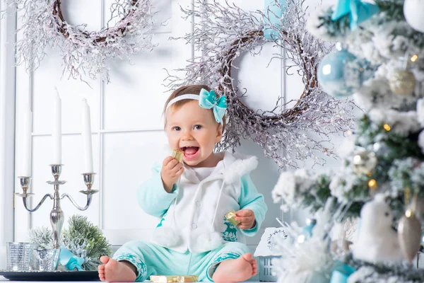 달콤한 작은 소녀는 초콜릿 캔디를 먹고 있다. 크리스마스 분위기. — 스톡 사진