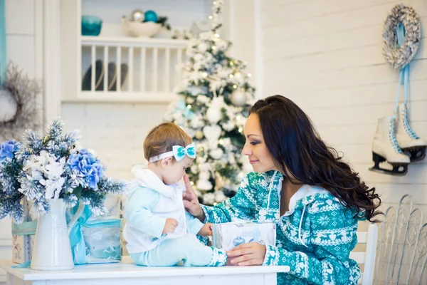 Mamá e hija abren un regalo en un estado de ánimo navideño . —  Fotos de Stock