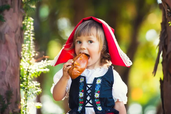 Little Red Riding Hood kouše patty v lese. — Stock fotografie