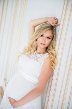 Beyaz dantel elbise gebelikte. Bebek bekliyor.