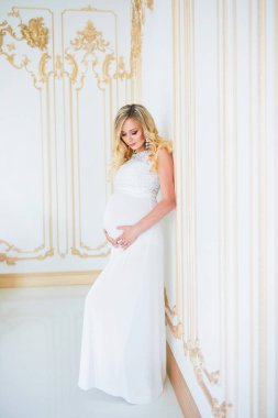 Beyaz dantel elbise gebelikte. Bebek bekliyor.