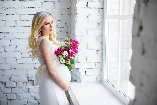 赤ちゃんを待っている花の花束と美しい妊娠中の女性。妊娠. — ストック写真