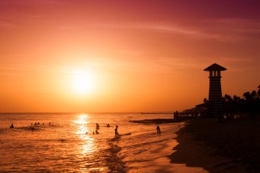 Karayip Denizi'nin kıyısında çizgili kırmızı beyaz feneri. Dominik Cumhuriyeti.