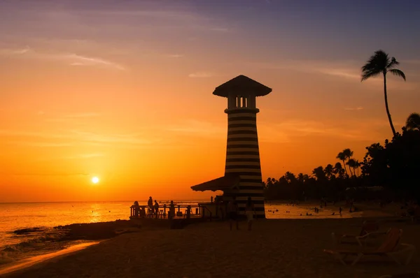 Csíkos piros fehér világítótorony a Karib-tenger partján. Dominikai Köztársaság. — Stock Fotó